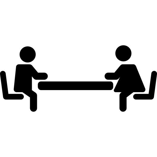 Sister and brother sitting one in front of the other on a table waiting for lunch